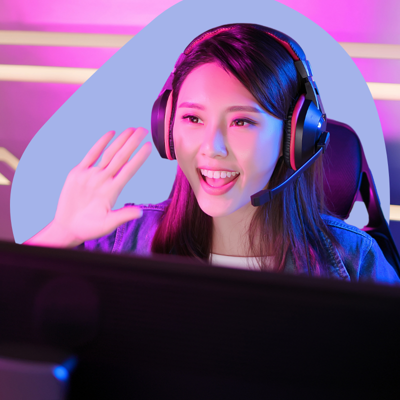 A gamer livestreamer waves to her audience. She's wearing a gaming headset.