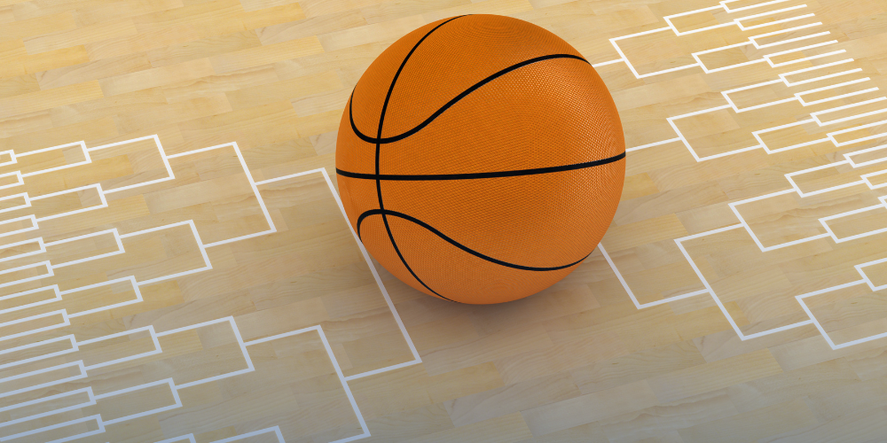 A basketball sit on the floor with a tournament bracket graphic