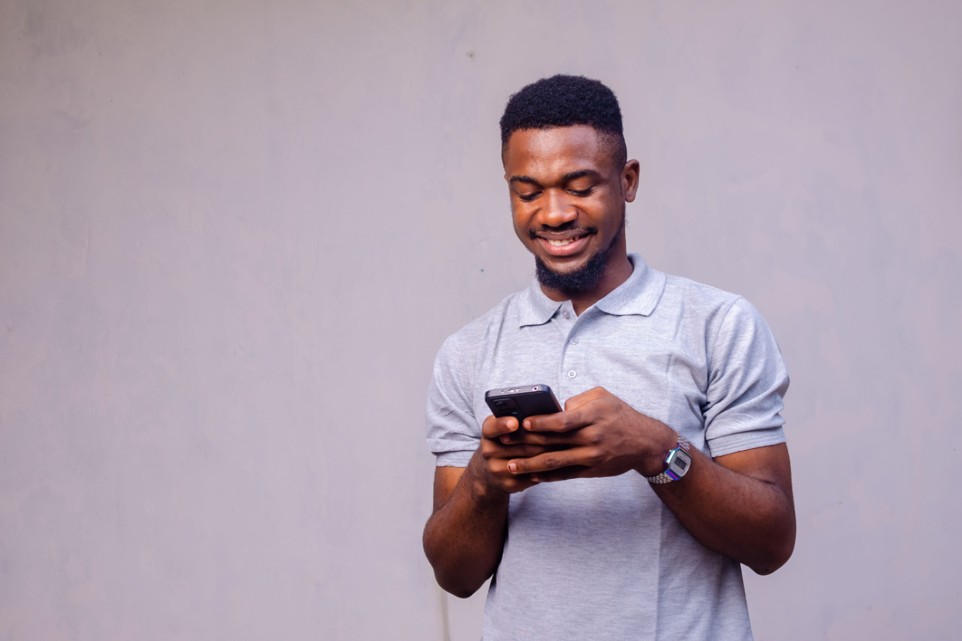 a male looking at his phone smiling