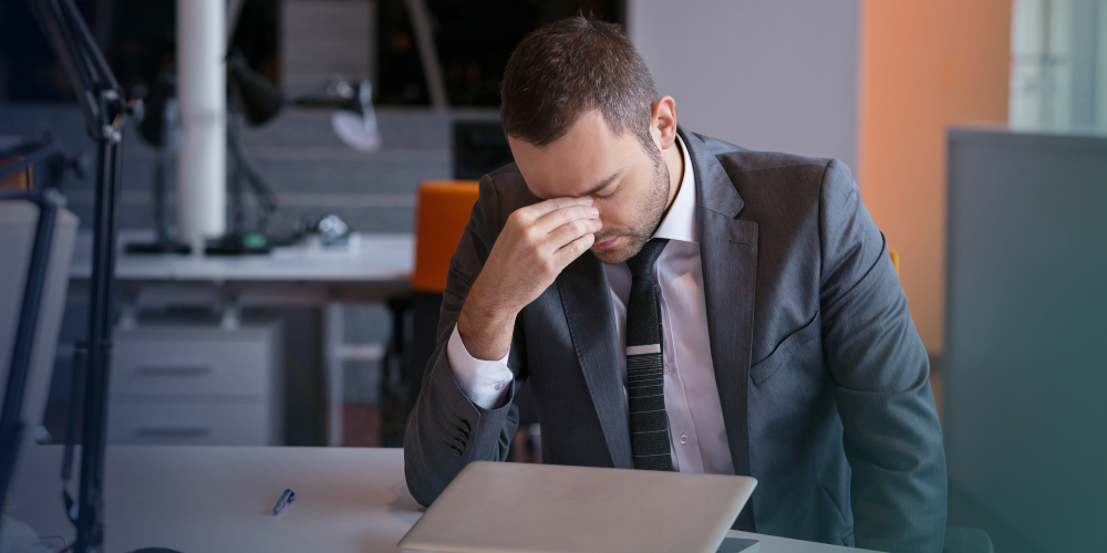 A man in a suit is stressed at work