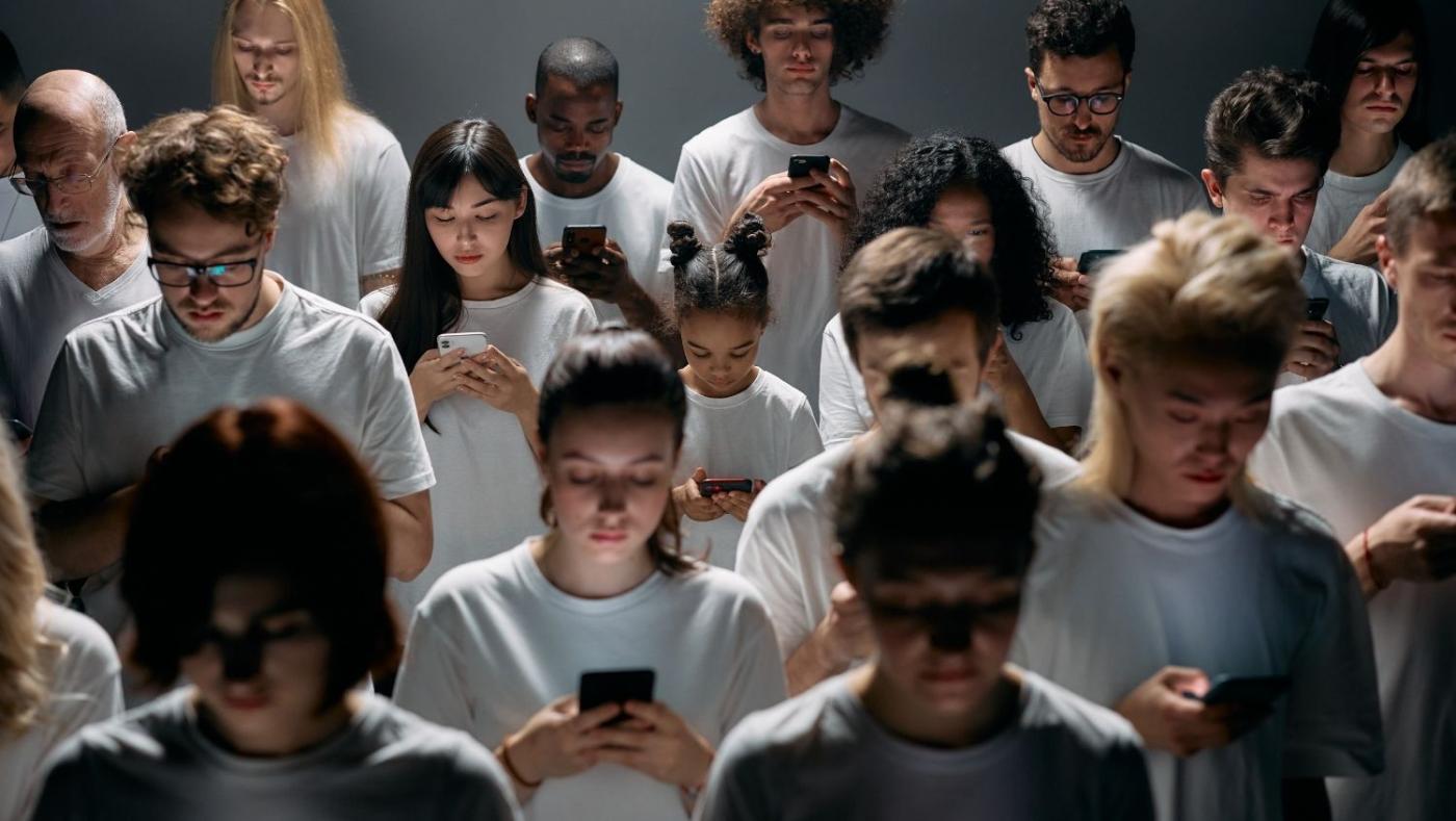 Imagen de un grupo de personas mirando las pantallas de celulares.