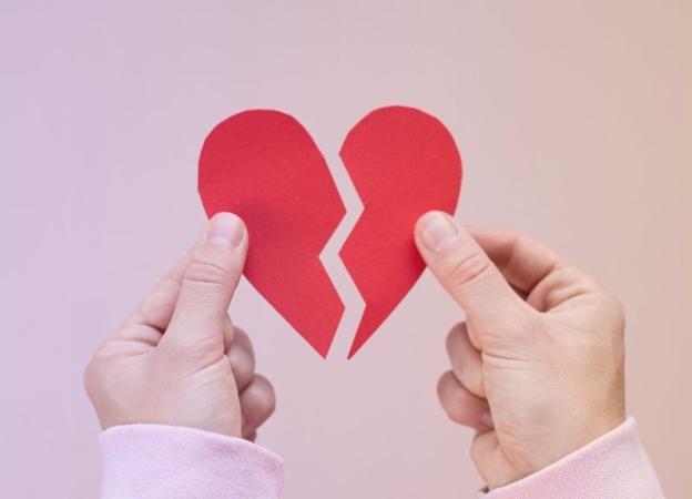 Manos sosteniendo un corazón de papel roto, simbolizando el sentimiento de un sistema roto y la desconfianza en las élites en América Latina