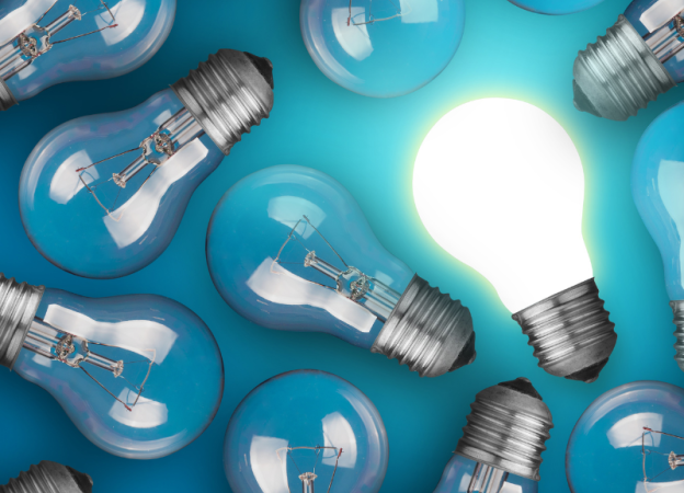 A group of lightbulbs on a blue background. One lighbulb is lit.