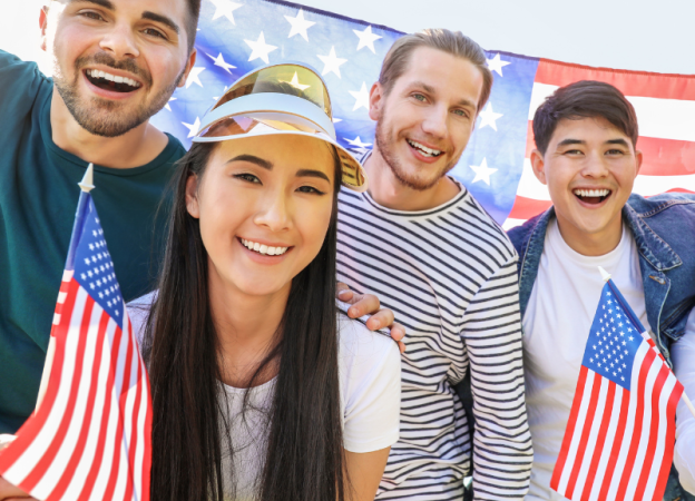 Four adults hold American flags and smile