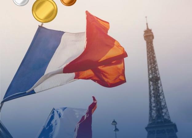 Imagen de banderas francesas en París, de fondo se aprecia la Torre Eiffel.