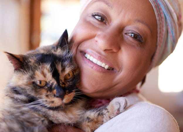 A woman cuddles her cat close to her face