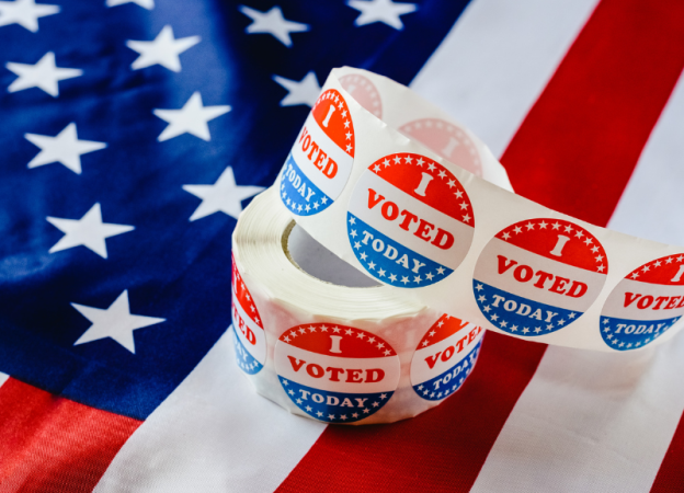 A roll of 'I Voted Today' stickers sitting on an American flag
