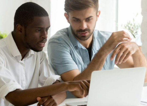 Two men sitting in front of the monitor screen wondering what happened 