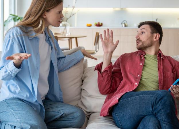 Imagen de una pareja discutiendo en un sofá