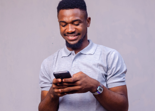 a male looking at his phone smiling