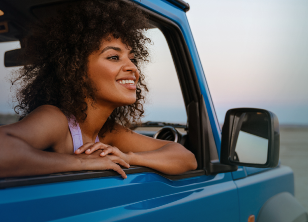 A woman leans on the window of a car