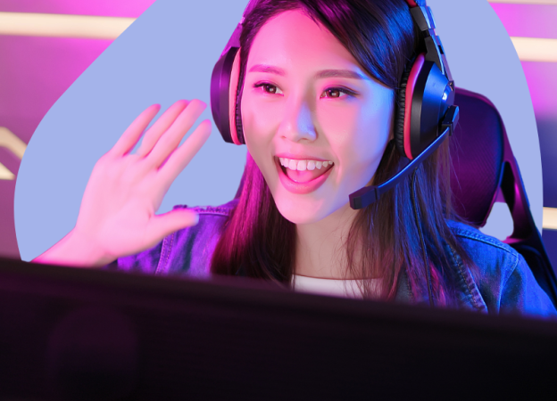 A gamer livestreamer waves to her audience. She's wearing a gaming headset.