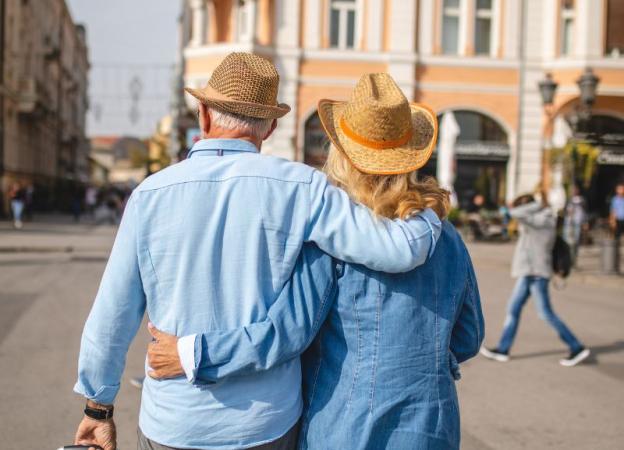 Imagen de una pareja de turistas caminando abrazada. 