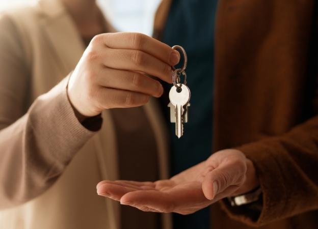 imagen de una persona entregando las llaves de una vivienda a otra.